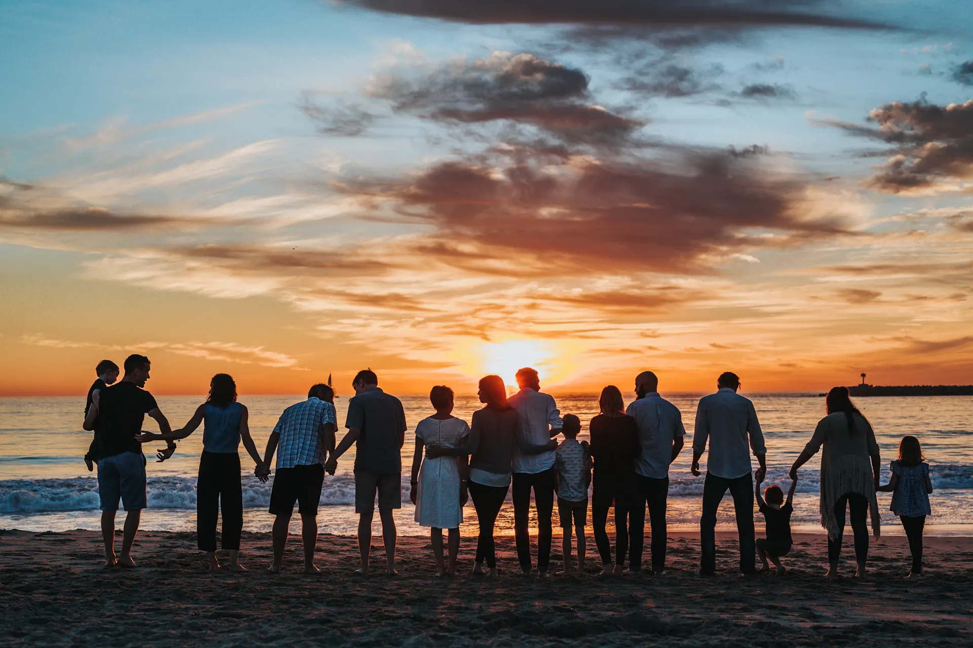 Familia caminando en la playa al atardecer